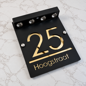 LumiSpot in Zwart / goud: zwart huisnummerbord met gouden letters en vier led-spotjes op zonne-energie
