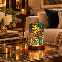 Tiffany Libellelamp Cilinder op een marmeren tafel met gouden dienblad naast de bank, met warm licht door het gekleurde glas