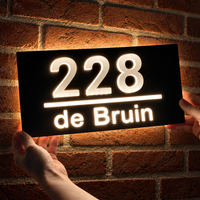 LumiRelief verlicht huisnummerbord voor een stenen gevel: 228 de Bruin licht warm wit op