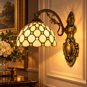 Tiffany wandlamp, ontwerp Honing: crèmekleurig glas-in-lood met amberkleurige glasparels, brandend aan de muur