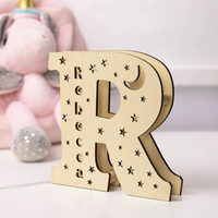 Houten letterlamp R met naam Rebecca gegraveerd, sterren en maan, op nachtkastje in babykamer
