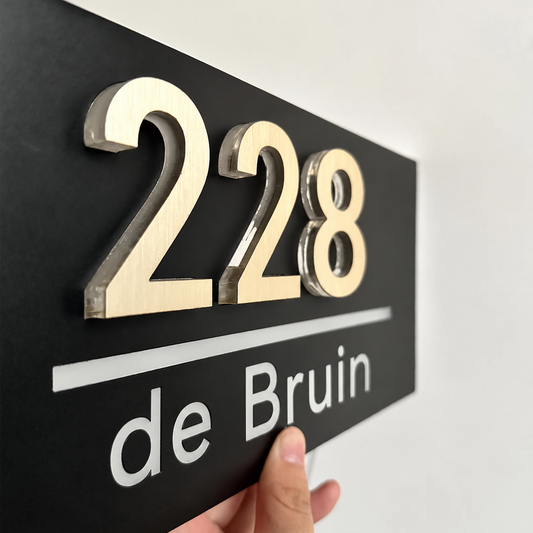 Verlicht huisnummerbord LumiRelief met goudkleurige 3D-cijfers van dichtbij: 228 de Bruin op zwart acryl