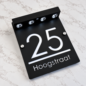LumiSpot in Zwart / wit: zwart huisnummerbord met witte letters en vier led-spotjes op zonne-energie