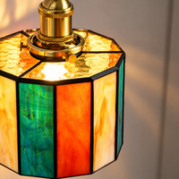 Tiffany hanglamp Retrostreep aan: warm licht door het groene, oranje en crèmekleurige glas-in-lood