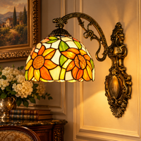 Tiffany wandlamp Zonnebloem in warm licht: glas-in-lood met oranje zonnebloemen en groene bladeren