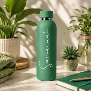 Groene RVS drinkfles met gegraveerde naam tussen kamerplanten en vetplanten