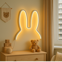 SnuffiLight witte konijn LED nachtlamp op ladekast in kinderkamer met houten letterblokken en teddybeer