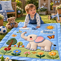 Baby op de blauwe olifanten speeldeken met de naam Lucas in de tuin
