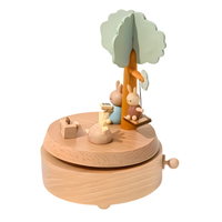 Houten muziekdoos vooraanzicht met konijntjes, boekje en lammetje rond een boom op draaiende basis